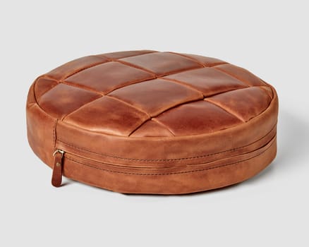Elegant round floor cushion featuring brown leather patchwork design with quilted top and side zipper detail. Artisanal leather goods