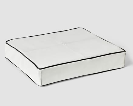 Elegant square white leather floor cushion featuring crisp black edge, presented against seamless white backdrop. Handcrafted interior design item