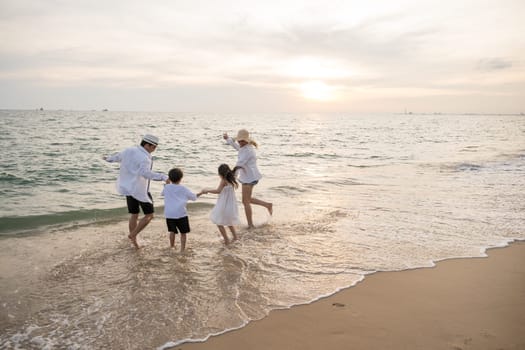 Scenic beach view at sunset portraying parents and kids sharing quality time on holiday. heartwarming summer vacation scene with happy mother father and children running in ocean enjoying.