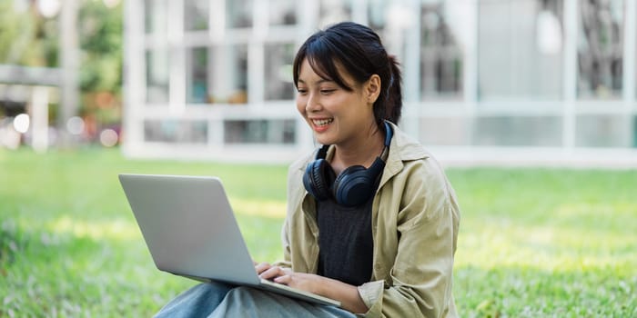 Young Asian student sitting and using laptop at university before class room. education, back to school concept.