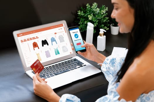 Young woman order or purchase product on internet using laptop and make transaction payment by smartphone. Online shopping lifestyle with credit card via internet banking on mobile application. Blithe