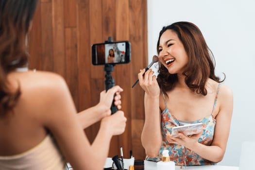 Woman influencer shoot live streaming vlog video review makeup uttermost social media or blog. Happy young girl with cosmetics studio lighting for marketing recording session broadcasting online.
