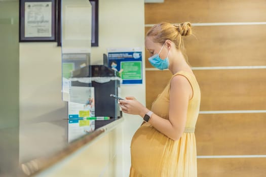 A pregnant woman stands at the hospital reception desk, embarking on a crucial phase of her maternity journey, seeking care and support in a healthcare setting.