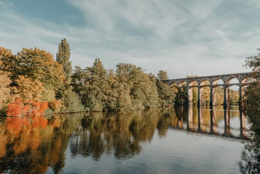 Railway Bridge with river in Bietigheim-Bissingen, Germany. Autumn. Railway viaduct over the Enz River, built in 1853 by Karl von Etzel on a sunny summer day. Bietigheim-Bissingen, Germany. Old viaduct in Bietigheim reflected in the river. Baden-Wurttemberg, Germany. Train passing a train bridge on a cloudy day in Germany