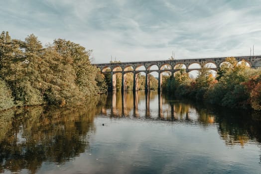 Railway Bridge with river in Bietigheim-Bissingen, Germany. Autumn. Railway viaduct over the Enz River, built in 1853 by Karl von Etzel on a sunny summer day. Bietigheim-Bissingen, Germany. Old viaduct in Bietigheim reflected in the river. Baden-Wurttemberg, Germany. Train passing a train bridge on a cloudy day in Germany