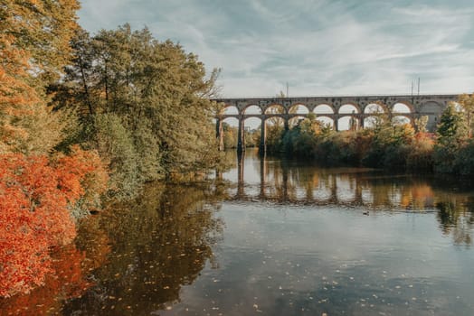 Railway Bridge with river in Bietigheim-Bissingen, Germany. Autumn. Railway viaduct over the Enz River, built in 1853 by Karl von Etzel on a sunny summer day. Bietigheim-Bissingen, Germany. Old viaduct in Bietigheim reflected in the river. Baden-Wurttemberg, Germany. Train passing a train bridge on a cloudy day in Germany