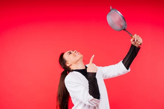 Happy young blonde woman sifts through sieve on red white bsckground in studio