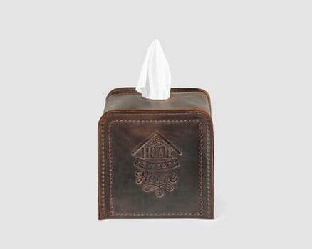 Stylish and convenient brown leather tissue box cover decorated with embossing, isolated on white background. Artisanal home decor accessory