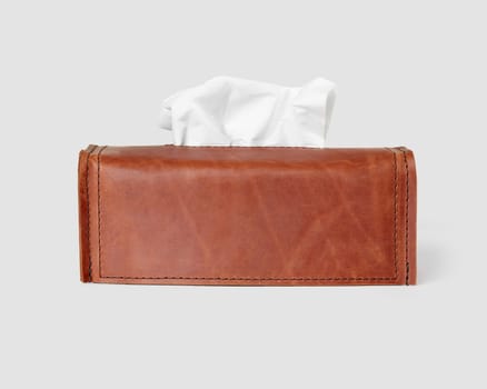 Rectangular brown leather tissue box cover personalized with embossed initials JFK, displayed on white background. Designed item for interior decor
