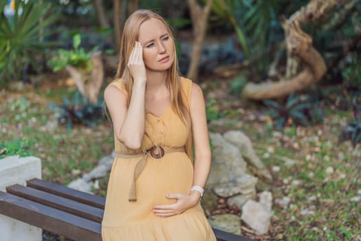 A pregnant woman experiences a moment of discomfort, grappling with a headache during pregnancy, highlighting the common challenge and the need for proper self-care and attention to maternal well-being.