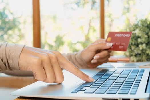 Close up credit card using for online payment, banking and shopping on the internet network with laptop computer showing credit card technology for online secured wallet top up and crucial purchase