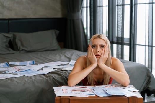 Stress worried young woman sit at table, as she pay bills online with credit card from financial debt problem, monthly expense and credit card debt. Over spending money lifestyle problem. Blithe