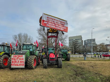 Farmers protest against the European Union anti-agricultural policy. Several agricultural tractors are parked in a field under the cloudy sky