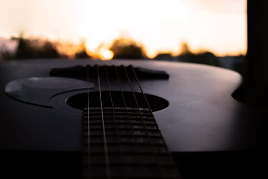 Guitar and strings on the background of a bright sunset