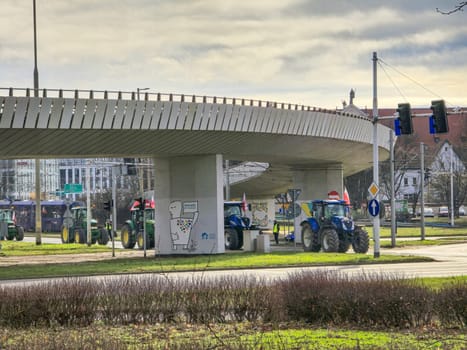Wroclaw, Poland, February 15, 2024: Farmers' protest against the European Union's anti-farmer policy. Several tractors are parked under a bridge High quality