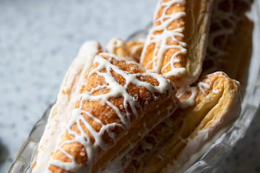 Puff pastry cookies with icing on the table close up