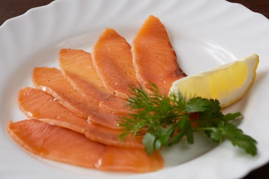 Restaurant food. Sliced salmon with lemon, close-up