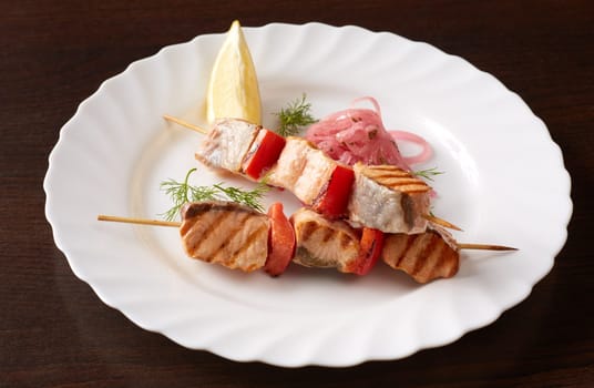 Skewers of tasty grilled fish and vegetables, close-up