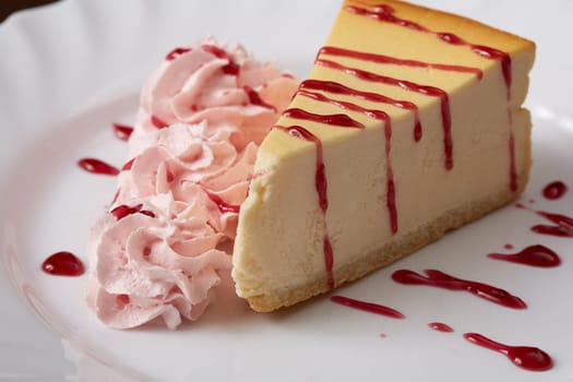 Delicious cheesecake with raspberry cream and syrup