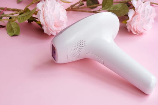 home modern laser epilator. Hair Remover offering Permanently Smooth Skin. Flash Epilator Laser on a pink background. Female blog concept. High quality photo