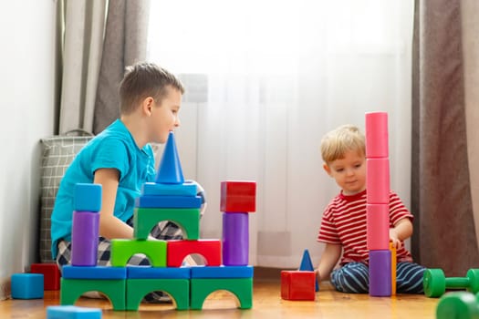 Two young children engaged in play with vibrant building blocks.