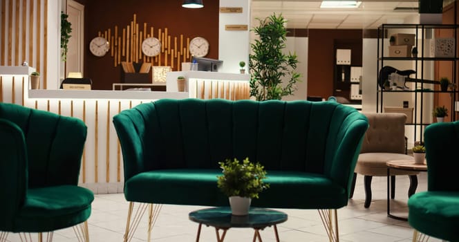 Crane down shot of welcoming rustic hospitality industry lobby interior filled with plants, waiting for guests. Empty cozy stylish hotel check in reception desk ready for arriving tourists