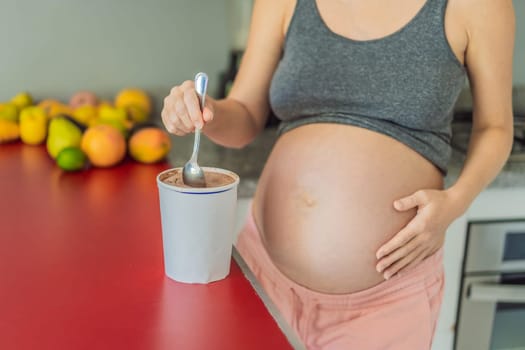 Happy pregnant young woman eating ice cream.