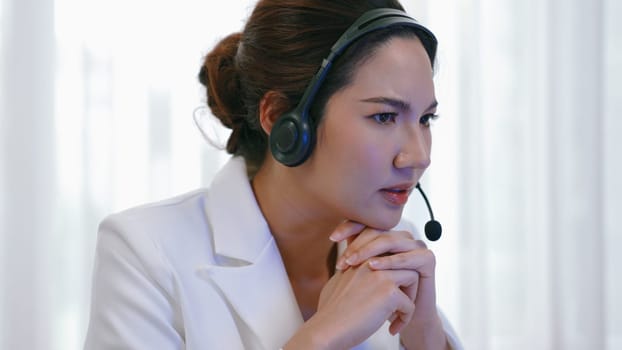 Businesswoman wearing headset working in office to support remote customer or colleague. Frustrated and tired call center customer support agent facing problem on providing vivancy service