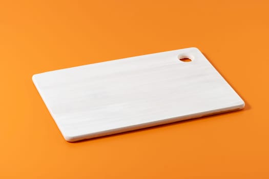 Wooden cutting board on the orange background. Mockup for your design. Product display for your food product with copy space.