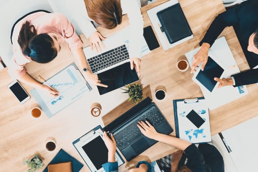 Top view of businessman executive in group meeting with other businessmen and businesswomen in modern office with laptop computer, coffee and document on table. People corporate business team uds