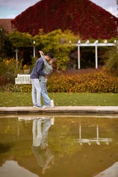 lovely young couple kissing outdoors in autumn. Loving couple walking in nature. Autumn mood. Happy man and woman hugging and kissing in autumn. Love. Fashionable couple outdoors. Fashion, people and lifestyle. Stylish couple in autumn outfit.