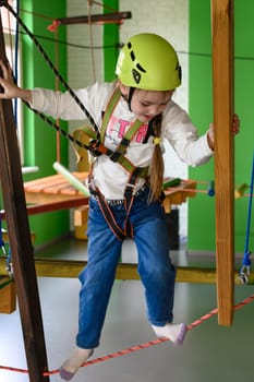 Happy girl passes the cableway, active recreation in the playroom, cable car for the physical development of the child.