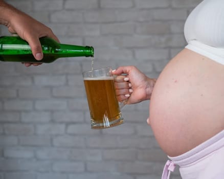 Man pouring beer for pregnant woman
