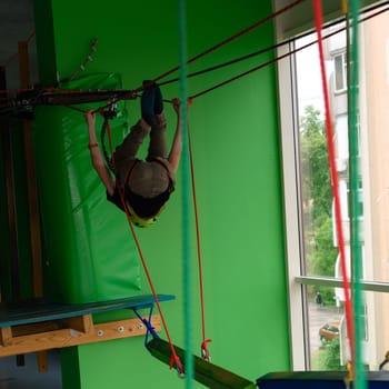 Ropeway is one of the types of physical development for children, a boy passes the ropeway in the playroom.
