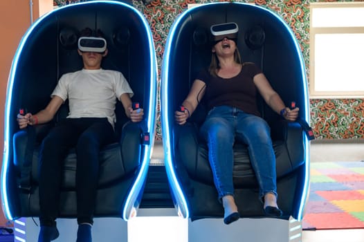 Virtual reality attraction, son and mother experience adrenaline from virtual reality, 5D sensation.