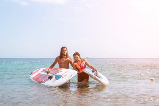 Close up shot of beautiful young caucasian woman with black hair and freckles looking at camera and smiling. Cute woman portrait in a pink bikini posing on a volcanic rock high above the sea