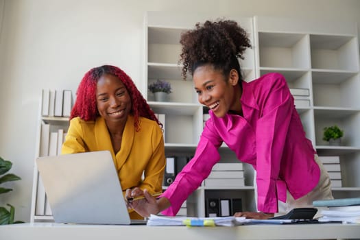 Two businesswoman African American working together using laptop and talking about a business project. team of females executive meeting work in office.