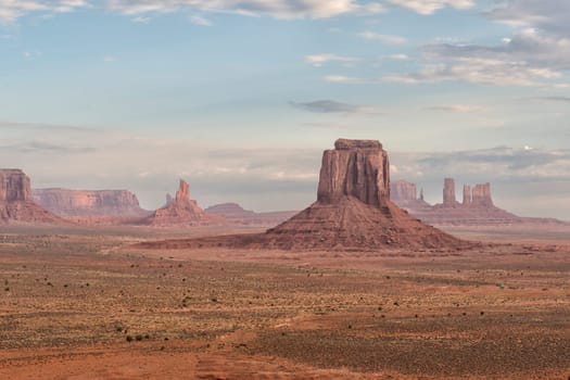 Monument Valley view at sunset with wonderful cloudy sky and lights on mittens