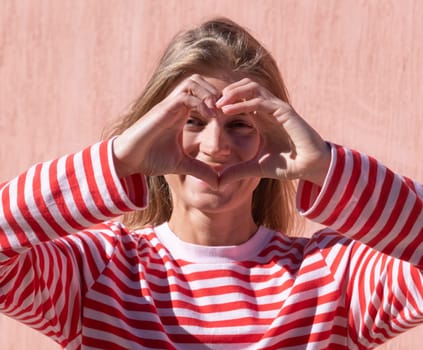 Female hands making sign Heart by fingers. Beautiful hands of woman with copy space. Love concept on Valentine day.