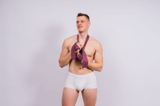 Young bodybuilder working out with rubber band over a white and dark background