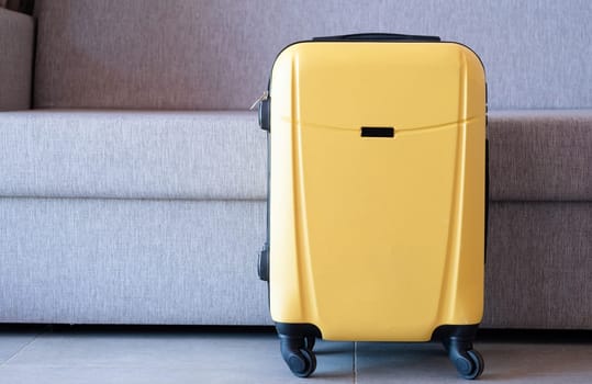 yellow suitcases on sofa background in hotel room, copy space