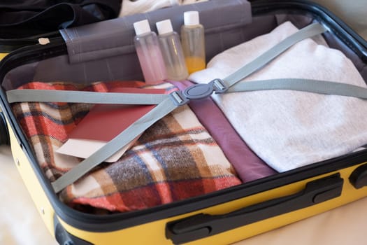 happy woman preparing for holidays, packing suitcase on bed