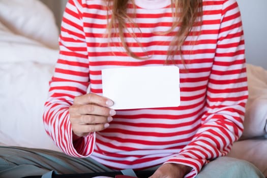 happy woman preparing for holidays, packing suitcase on bed, woman holding a blank boarding pass