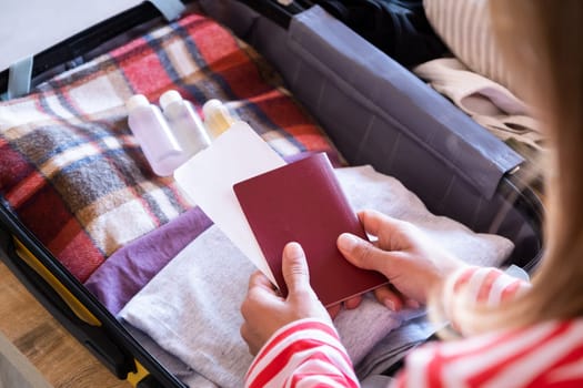 happy woman preparing for holidays, packing suitcase on bed