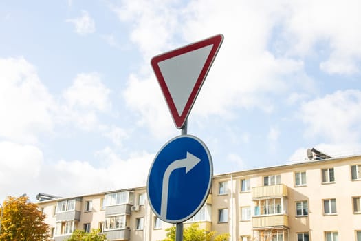 Give way road sign on blue sky background close up