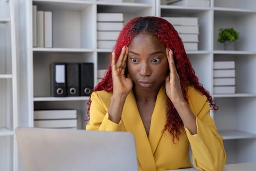 African American businesswoman has fatigue and headaches from working in the office..