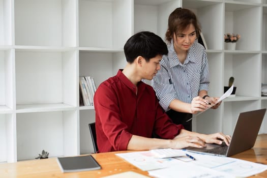 Cheerful business lady working on laptop in office, Asian happy beautiful businesswoman in formal suit work in workplace.