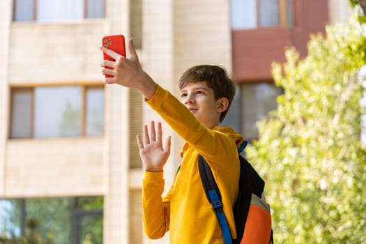 A young boy is having a video call, holding a smartphone in his hands