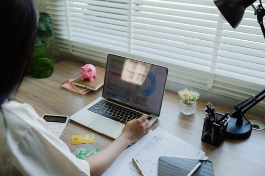 young woman checking bills, taxes, bank account balance and calculating expenses in the living room at home.