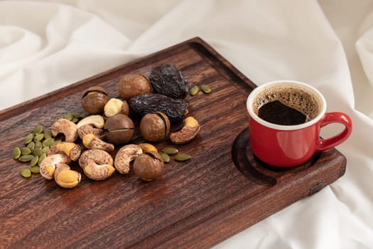 A tasty charcuterie board full of various nuts and coffee for breakfast
